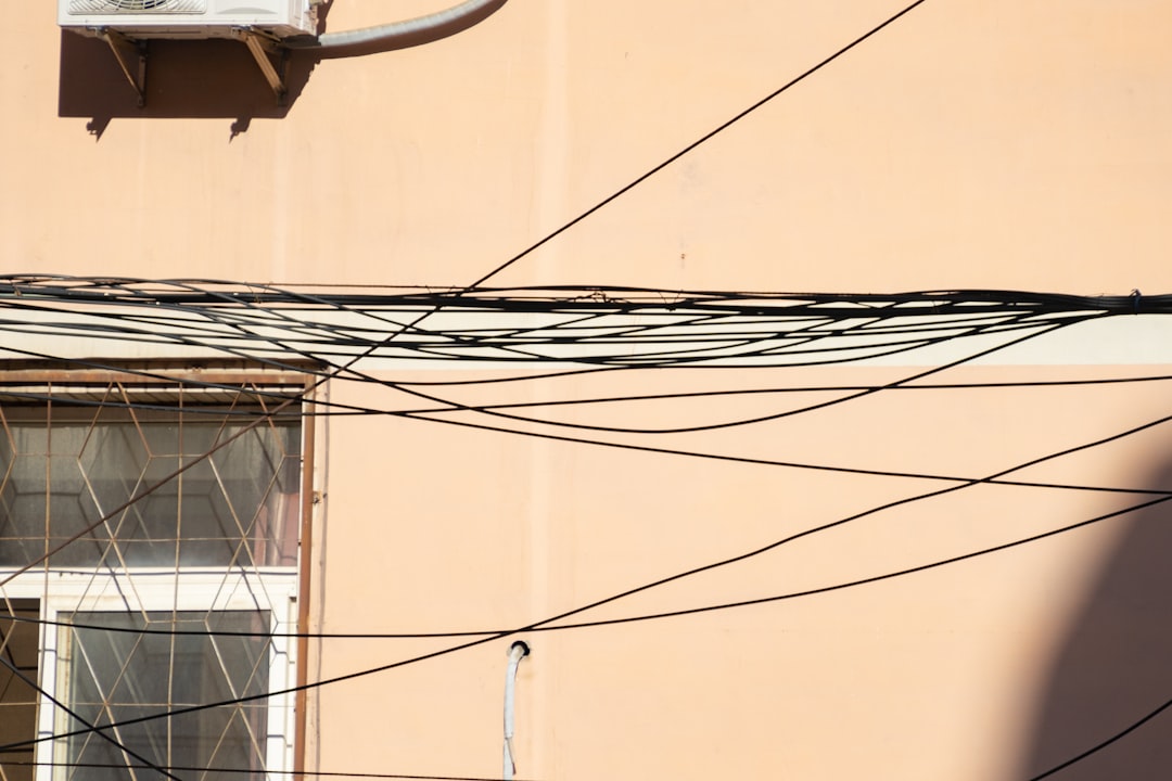 tangled network cables - a pink building with lots of wires and a window